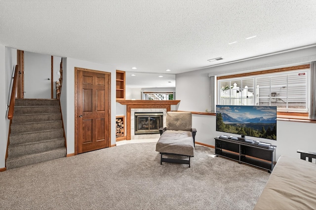 5711 Donegal Dr, Shoreview, MN 55126 - carpeted living room featuring stairs, a textured ceiling, a glass covered fireplace, and recessed lighting