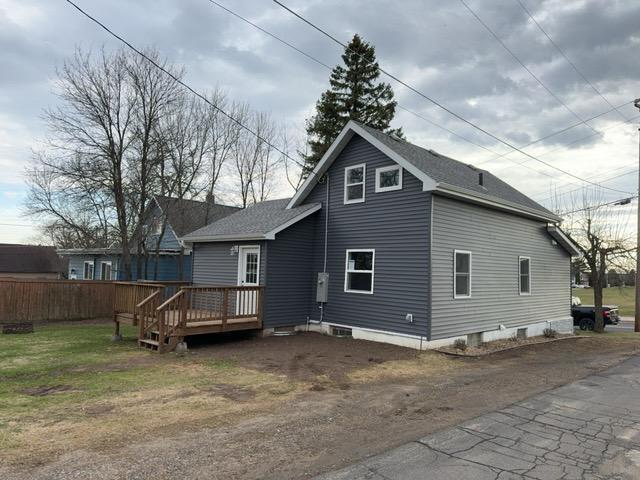 402 Elba Ave, Eveleth, MN 55734 - back of property featuring a deck, a shingled roof, and driveway
