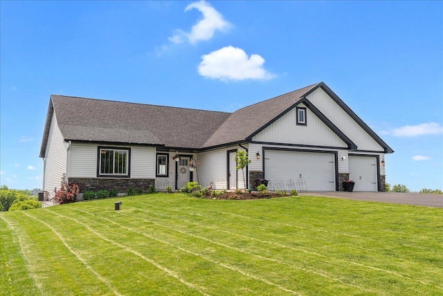1609 75th Ave, Hammond, WI 54015 - modern farmhouse featuring stone siding, an attached garage, a front yard, driveway, and roof with shingles