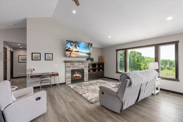 1609 75th Ave, Hammond, WI 54015 - living room with wood finished floors, a stone fireplace, high vaulted ceiling, and recessed lighting