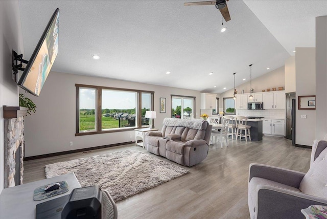 1609 75th Ave, Hammond, WI 54015 - living area featuring light wood-style flooring, vaulted ceiling, a ceiling fan, a textured ceiling, and recessed lighting