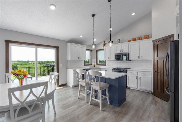 1609 75th Ave, Hammond, WI 54015 - kitchen featuring appliances with stainless steel finishes, a kitchen island, light countertops, decorative backsplash, and white cabinets