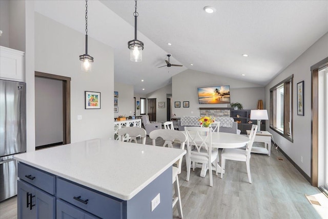 1609 75th Ave, Hammond, WI 54015 - kitchen featuring stainless steel fridge, vaulted ceiling, light wood-style flooring, blue cabinets, and open floor plan
