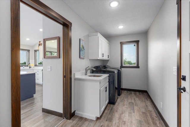 1609 75th Ave, Hammond, WI 54015 - laundry room featuring cabinet space, light wood finished floors, separate washer and dryer, a textured ceiling, and recessed lighting