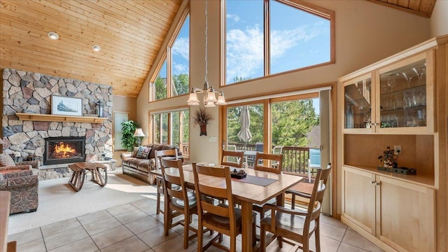 4132 Omaha Ln NW, Alexandria, MN 56308 - dining space featuring high vaulted ceiling, light tile patterned floors, a chandelier, wood ceiling, and a fireplace