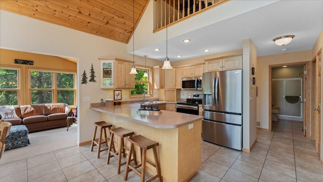 4132 Omaha Ln NW, Alexandria, MN 56308 - kitchen featuring appliances with stainless steel finishes, light brown cabinets, a peninsula, light tile patterned floors, and lofted ceiling
