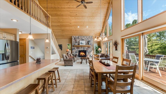 4132 Omaha Ln NW, Alexandria, MN 56308 - dining area featuring high vaulted ceiling, light tile patterned floors, a stone fireplace, wooden ceiling, and ceiling fan