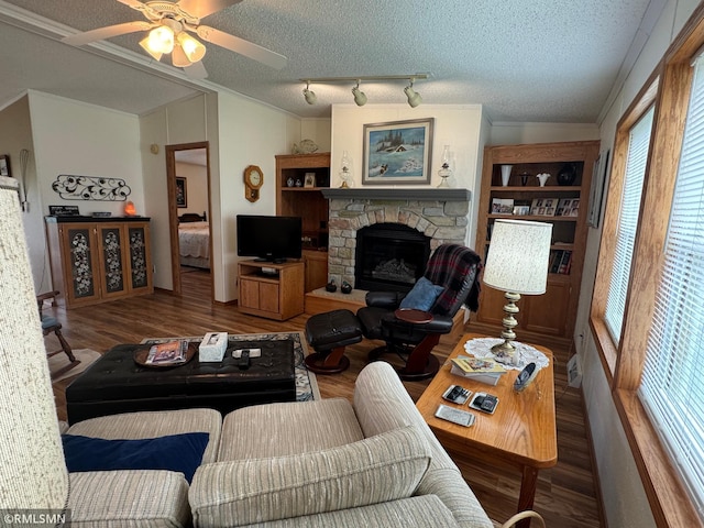 18755 Cassie Ln, Pokegama Twp, MN 55063 - living room featuring plenty of natural light, wood finished floors, a stone fireplace, ceiling fan, and a textured ceiling
