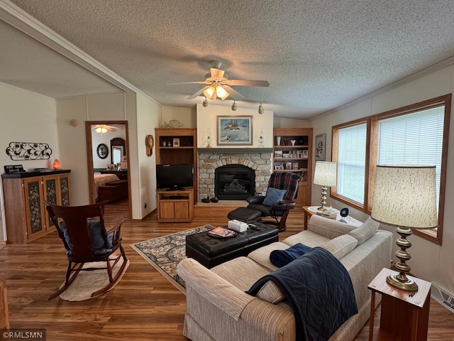 18755 Cassie Ln, Pokegama Twp, MN 55063 - living area featuring a ceiling fan, ornamental molding, wood finished floors, a stone fireplace, and a textured ceiling