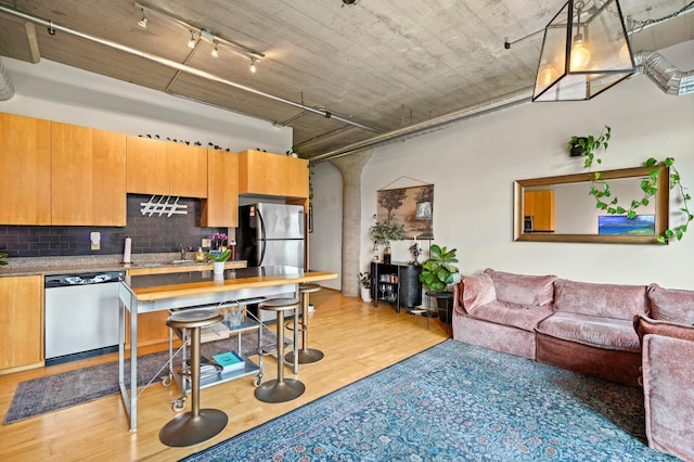 748 3rd St N Unit 504, Minneapolis, MN 55401 - kitchen featuring appliances with stainless steel finishes, backsplash, light wood-style flooring, open floor plan, and a sink