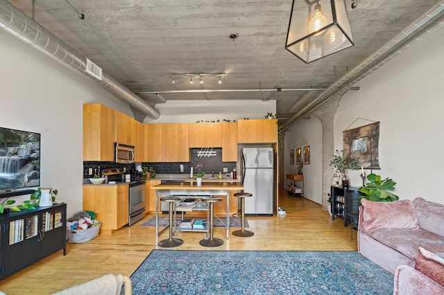 748 3rd St N Unit 504, Minneapolis, MN 55401 - kitchen with stainless steel appliances, light wood-style flooring, and decorative backsplash