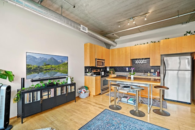 748 3rd St N Unit 504, Minneapolis, MN 55401 - kitchen with appliances with stainless steel finishes, light wood-style floors, backsplash, light countertops, and a sink