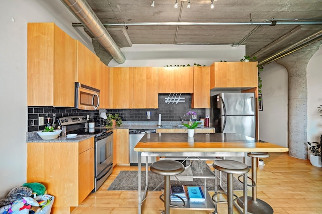 748 3rd St N Unit 504, Minneapolis, MN 55401 - kitchen with appliances with stainless steel finishes, light wood finished floors, and tasteful backsplash