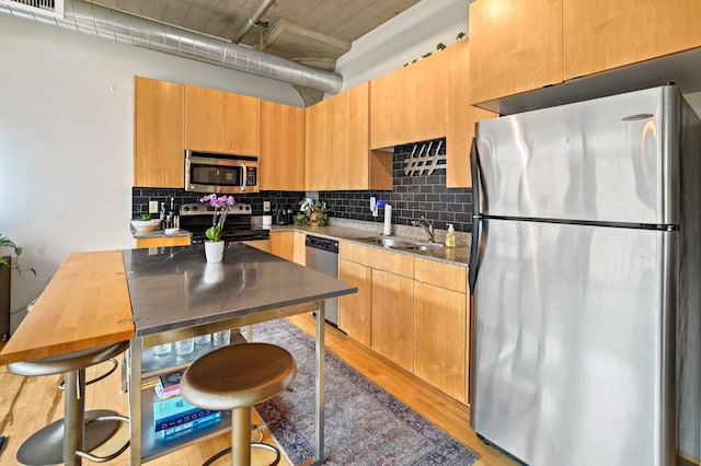 748 3rd St N Unit 504, Minneapolis, MN 55401 - kitchen featuring stainless steel appliances, tasteful backsplash, light wood finished floors, and a sink