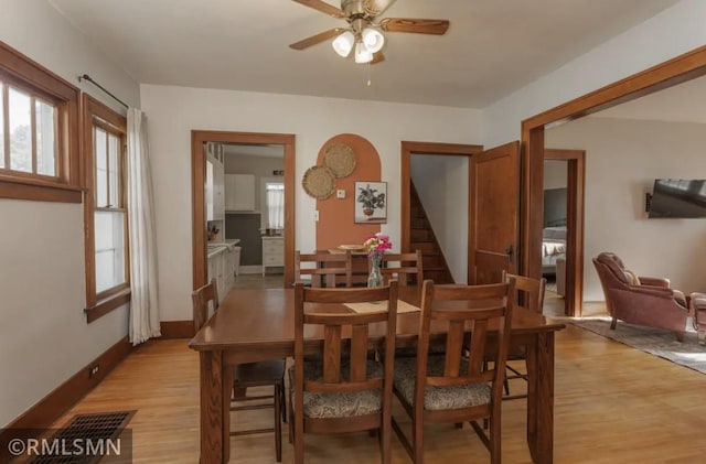 305 7th Ave E, Alexandria, MN 56308 - dining area with ceiling fan, light wood-type flooring, stairway, and baseboards