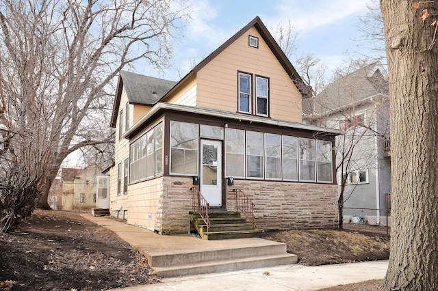 420 Lafond Ave, Saint Paul, MN 55103 - view of front of house with entry steps, a sunroom, stone siding, and a shingled roof