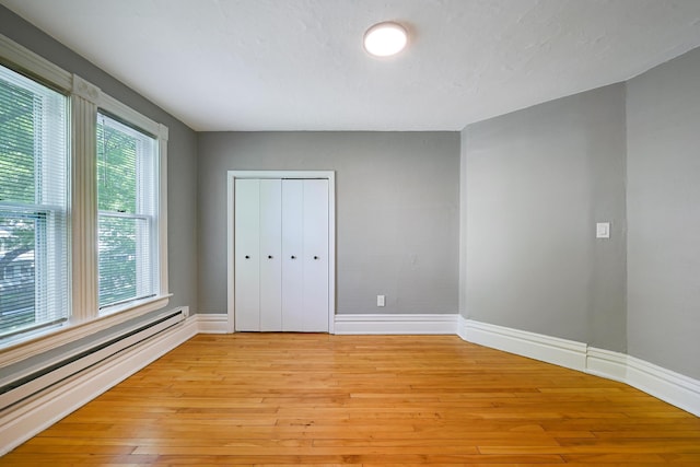 420 Lafond Ave, Saint Paul, MN 55103 - unfurnished bedroom featuring a baseboard heating unit, multiple windows, and baseboards