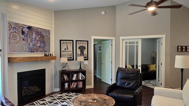 1300 Event Center Dr NE # 23, Bemidji, MN 56601 - living room featuring ceiling fan, wood finished floors, a glass covered fireplace, a towering ceiling, and baseboards