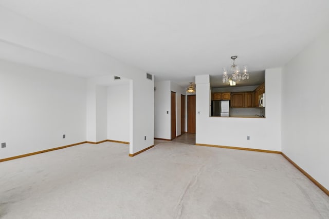 1425 28th St Unit 201, Minneapolis, MN 55408 - unfurnished living room with a chandelier, light carpet, and baseboards