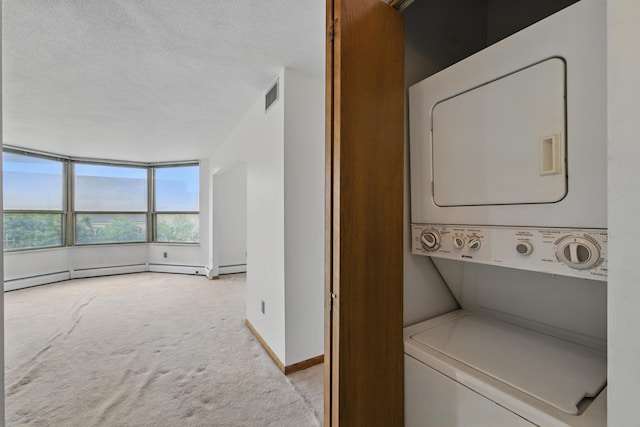1425 28th St Unit 201, Minneapolis, MN 55408 - laundry area featuring estacked washer and dryer, carpet flooring, a textured ceiling, baseboards, and baseboard heating