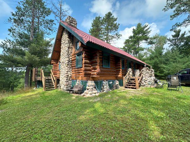 3547 Norway Ln, Ely, MN 55731 - view of side of home featuring stairway, log siding, a lawn, and a chimney