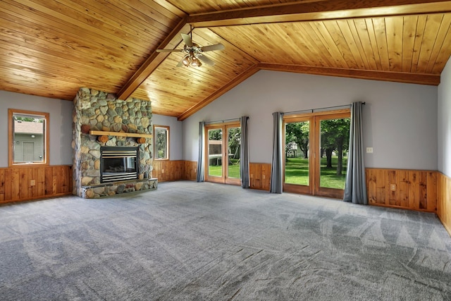 829 Cummings Ln, Saint Cloud, MN 56301 - unfurnished living room featuring a wainscoted wall, wood walls, carpet, a stone fireplace, and ceiling fan