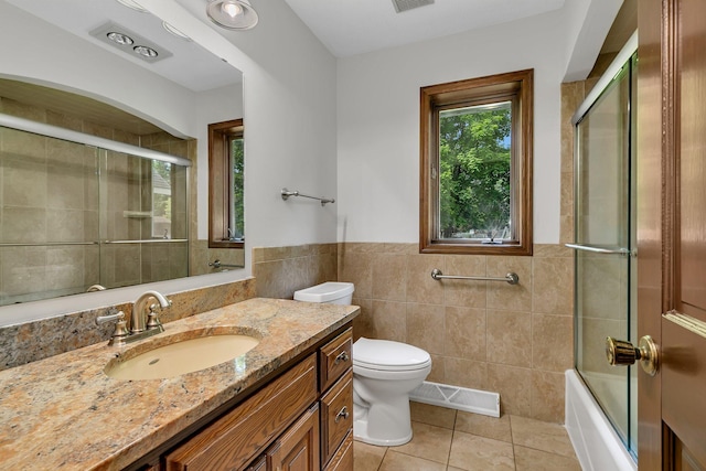 829 Cummings Ln, Saint Cloud, MN 56301 - bathroom with tile walls, tile patterned floors, vanity, toilet, and a wainscoted wall