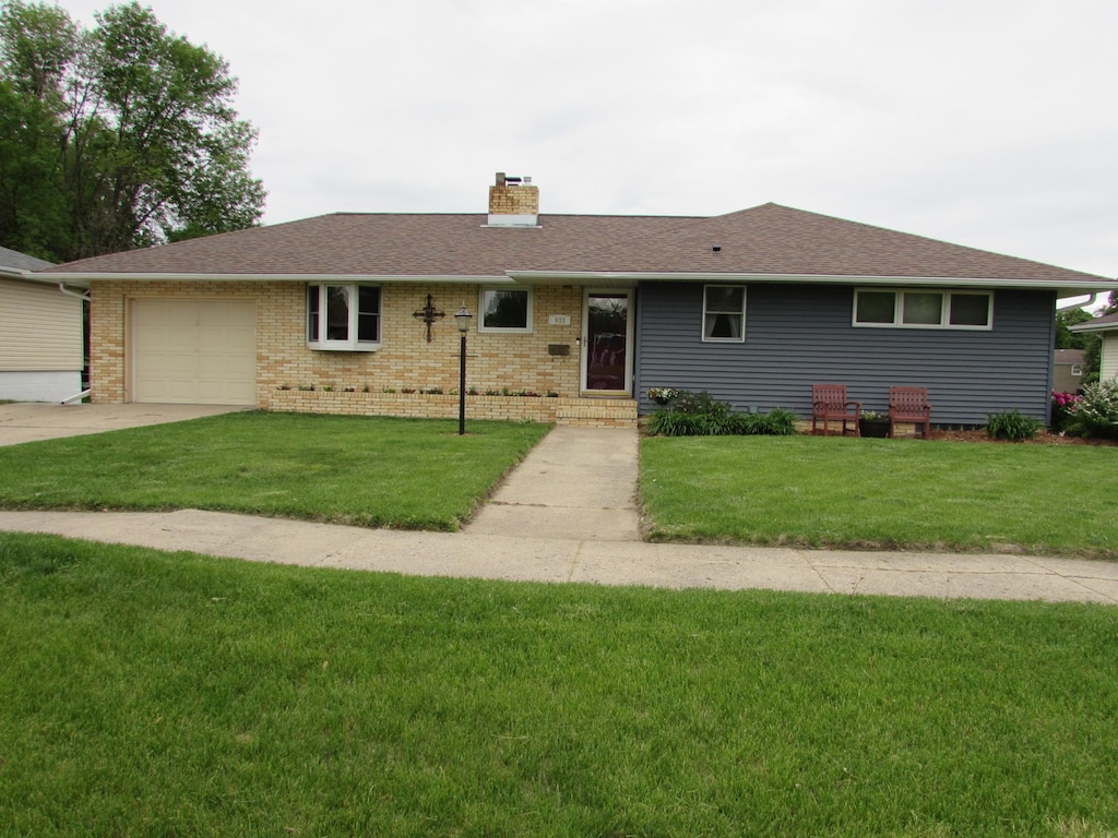 933 Hampton St, Fairmont, MN 56031 - single story home with a chimney, a garage, a front yard, driveway, and brick siding