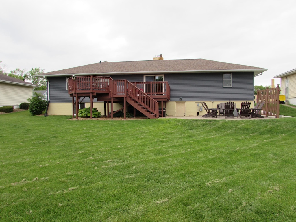 933 Hampton St, Fairmont, MN 56031 - rear view of house featuring a deck, stairs, a yard, and a chimney