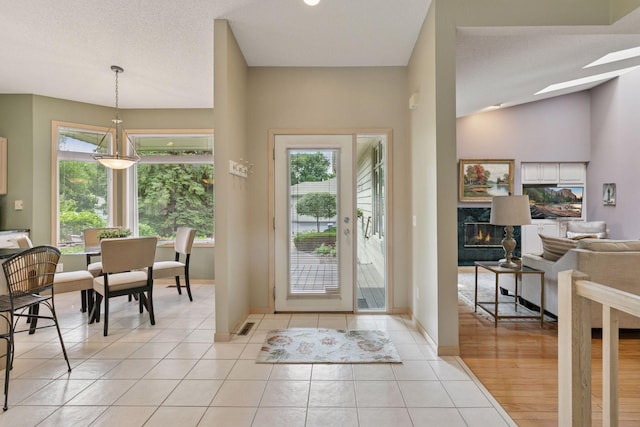 8910 Hilloway Rd, Eden Prairie, MN 55347 - foyer entrance with light tile patterned floors, a skylight, and lofted ceiling