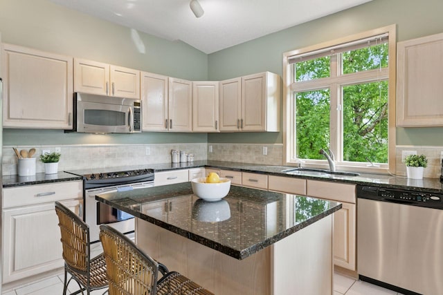 8910 Hilloway Rd, Eden Prairie, MN 55347 - kitchen with stainless steel appliances, light tile patterned floors, a kitchen bar, decorative backsplash, and dark stone countertops