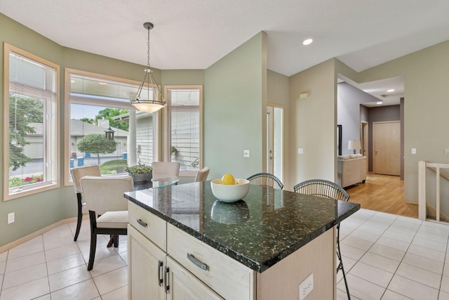 8910 Hilloway Rd, Eden Prairie, MN 55347 - kitchen featuring light tile patterned floors, a breakfast bar area, decorative light fixtures, a center island, and recessed lighting