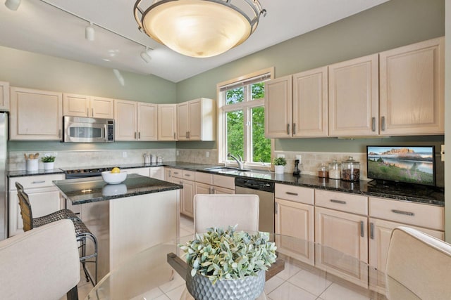 8910 Hilloway Rd, Eden Prairie, MN 55347 - kitchen featuring stainless steel appliances, a kitchen island, decorative backsplash, dark stone counters, and light tile patterned flooring