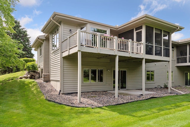 8910 Hilloway Rd, Eden Prairie, MN 55347 - rear view of house featuring a sunroom, a lawn, a patio, and a wooden deck