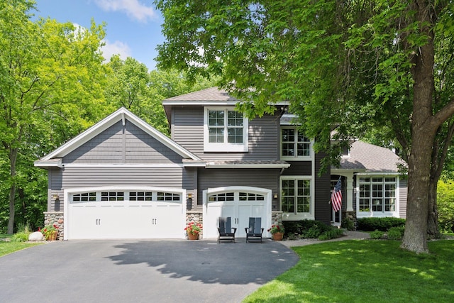 6253 Niagara Ct N, Maple Grove, MN 55311 - view of front of house with asphalt driveway, a front lawn, stone siding, and an attached garage