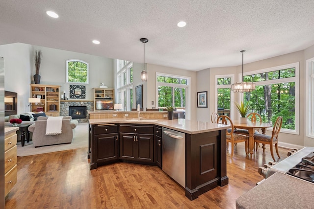 6253 Niagara Ct N, Maple Grove, MN 55311 - kitchen featuring dishwasher, a sink, a textured ceiling, dark brown cabinets, and plenty of natural light