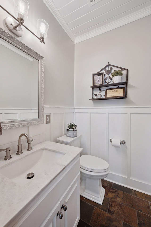 6253 Niagara Ct N, Maple Grove, MN 55311 - half bathroom featuring ornamental molding, vanity, toilet, stone tile flooring, and wainscoting