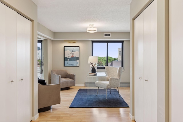 52 Groveland Ter Unit A402, Minneapolis, MN 55403 - living area featuring light wood finished floors, baseboards, and a textured ceiling