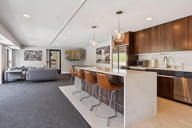 52 Groveland Ter Unit A402, Minneapolis, MN 55403 - kitchen with modern cabinets, appliances with stainless steel finishes, a sink, a breakfast bar area, and recessed lighting