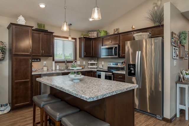 641 Beverly St, Wanamingo, MN 55983 - kitchen featuring appliances with stainless steel finishes, dark brown cabinetry, wood finished floors, light countertops, and lofted ceiling