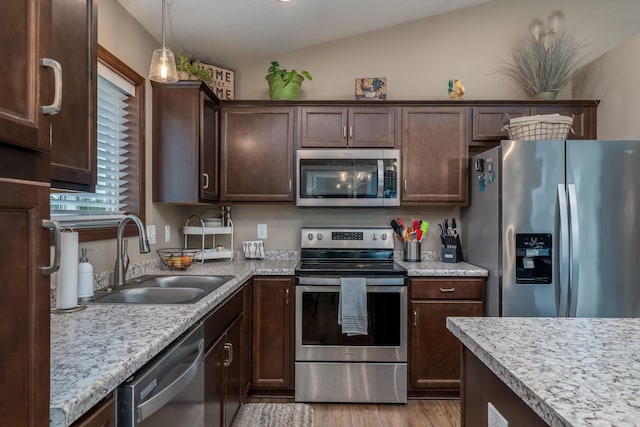 641 Beverly St, Wanamingo, MN 55983 - kitchen featuring appliances with stainless steel finishes, a sink, dark brown cabinetry, light wood finished floors, and hanging light fixtures