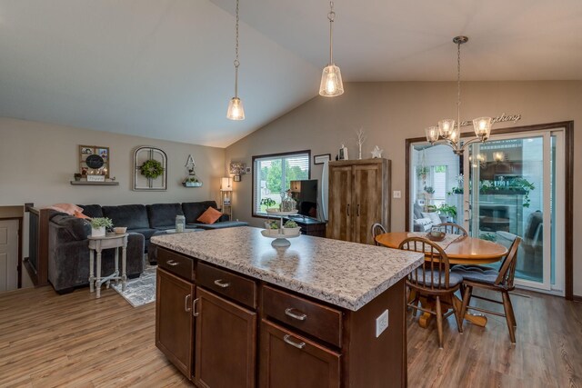 641 Beverly St, Wanamingo, MN 55983 - kitchen featuring light wood-style flooring, vaulted ceiling, a chandelier, light countertops, and decorative light fixtures