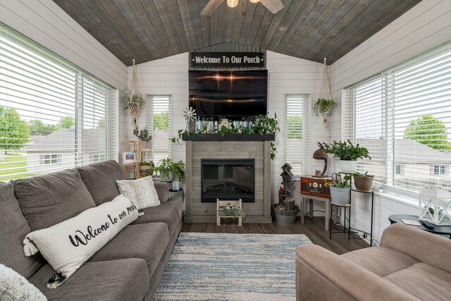 641 Beverly St, Wanamingo, MN 55983 - living area with lofted ceiling, a glass covered fireplace, wooden walls, ceiling fan, and wood finished floors