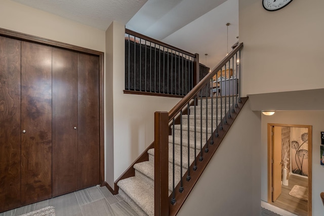 641 Beverly St, Wanamingo, MN 55983 - stairway featuring baseboards and a towering ceiling