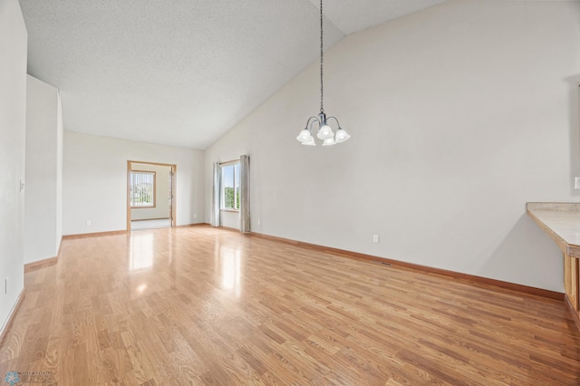 4388 52nd St S, Fargo, ND 58104 - unfurnished room featuring light wood-type flooring, a chandelier, and lofted ceiling