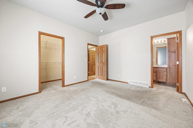 4388 52nd St S, Fargo, ND 58104 - unfurnished bedroom with light colored carpet, a spacious closet, ensuite bathroom, a closet, and ceiling fan