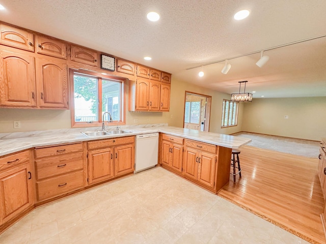 731 Grove Ave, Bird Island, MN 55310 - kitchen with white dishwasher, a sink, a peninsula, plenty of natural light, and recessed lighting