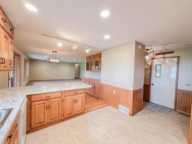 731 Grove Ave, Bird Island, MN 55310 - kitchen featuring a wainscoted wall, light countertops, a textured ceiling, wood walls, and dishwasher