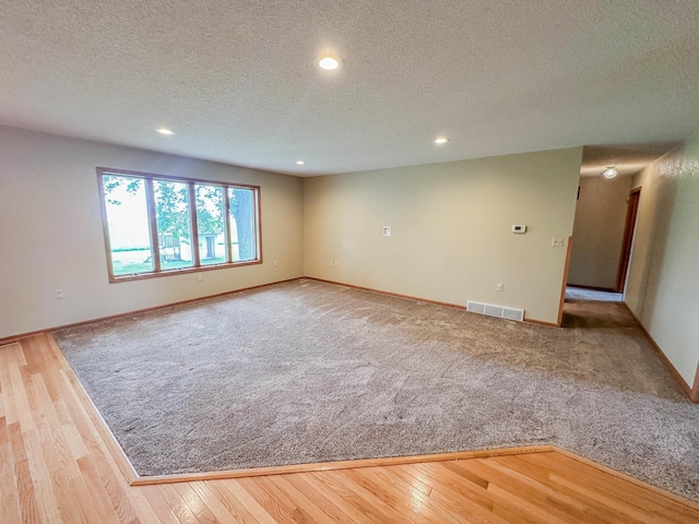 731 Grove Ave, Bird Island, MN 55310 - empty room featuring a textured ceiling, recessed lighting, baseboards, and wood finished floors
