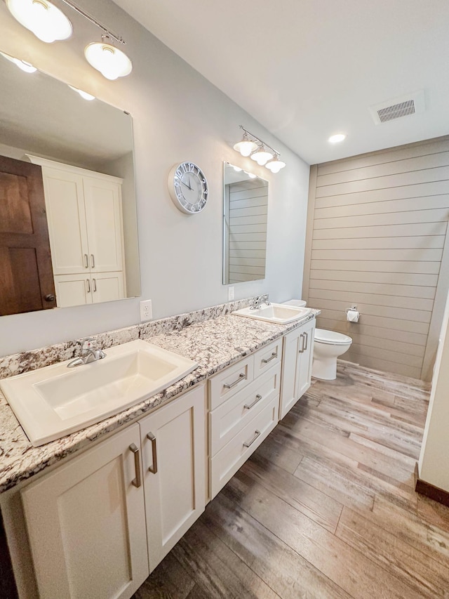 731 Grove Ave, Bird Island, MN 55310 - full bathroom featuring double vanity, toilet, and wood finished floors
